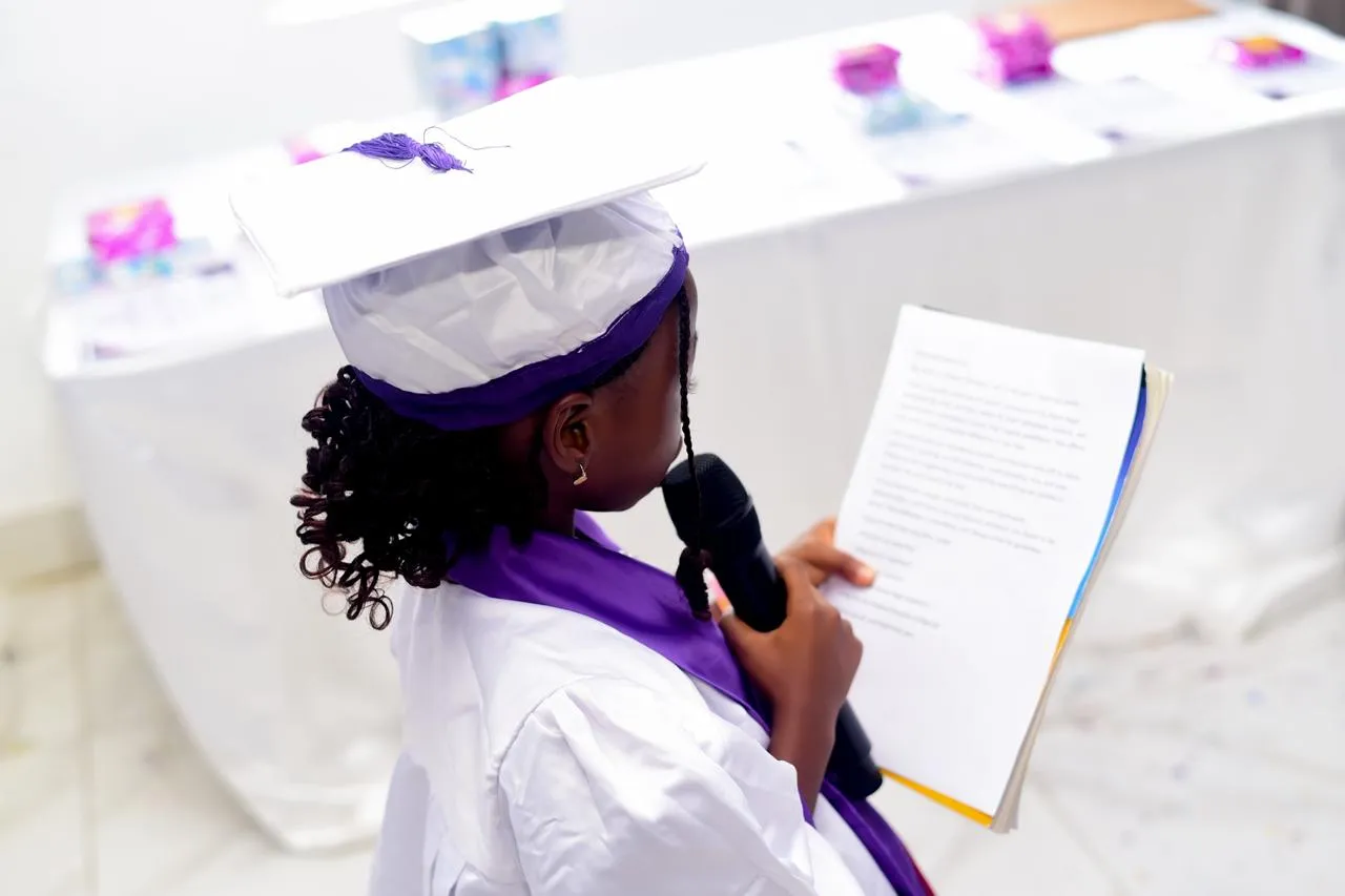 A young graduate reading aloud at a graduation ceremony