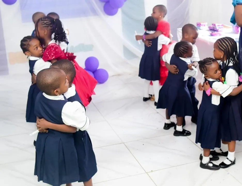 Pupils and staff embracing at a school celebration